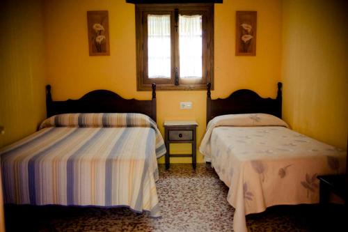 Un dormitorio con dos camas y una ventana. en Casa del Huerto, en El Bosque