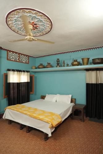 a bedroom with a bed and a blue wall at Sangam View Homestay Devprayag in Devaprayāg