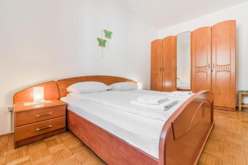 a bedroom with a large bed with a wooden headboard at Apartments Rombon Klavdij with Free Onsite Parking in Bovec