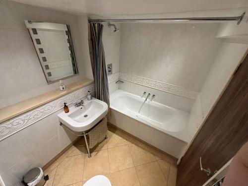 a bathroom with a sink and a tub and a toilet at Sams Wine Bar Harwich ltd in Harwich