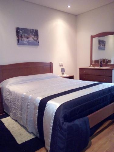a bedroom with a large bed and a mirror at A nossa Casa Gerês in Geres