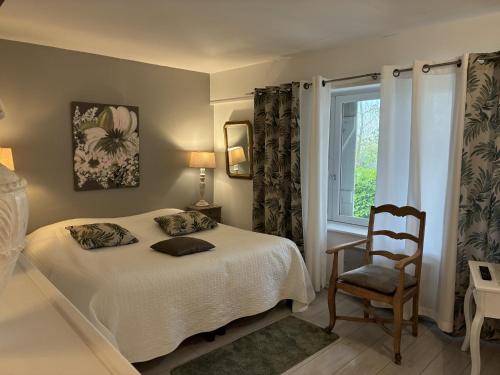 a bedroom with a bed and a chair and a window at La Gabetière in Estrablin