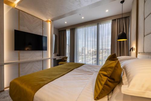 a bedroom with a large bed and a large window at East Plaza Hotel in Sofia