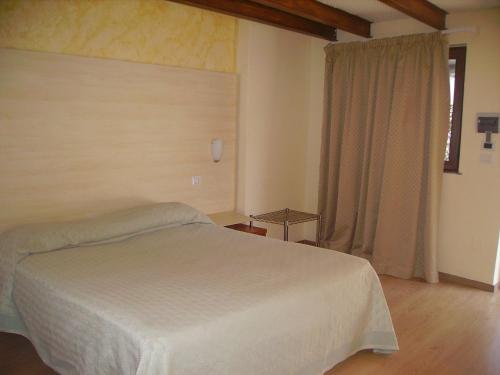 1 dormitorio con cama blanca y ventana en Hotel Angela e Vincenzo, en Cava deʼ Tirreni