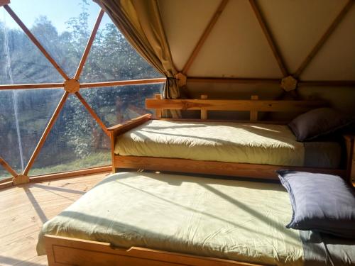 two beds in a room with a large window at Mush's rooms in Saint-Julien-Labrousse