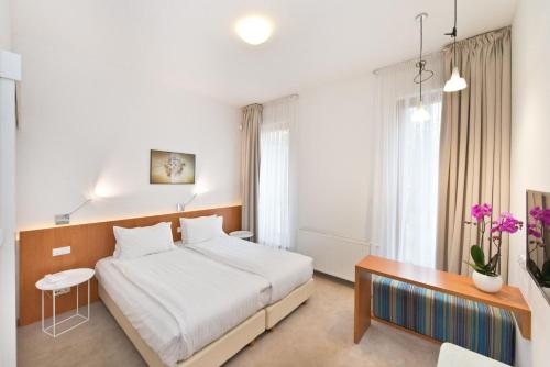 a hotel room with a bed and a desk at Villa 21 Victus by Noclegi Renters in Sopot