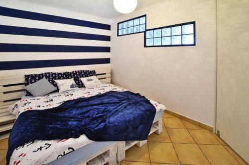 a bedroom with a bed with a blue and white striped wall at Kołobrzeg Osiedle Jantar in Kołobrzeg