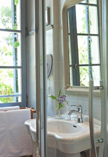 une salle de bain avec un lavabo et un miroir dans l'établissement Château de Lalande - Teritoria - Périgueux, à Annesse-et-Beaulieu