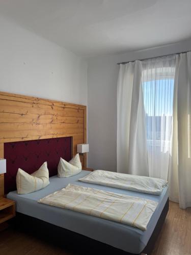 a bedroom with a large bed with a large window at Landgasthof Heerlein in Bamberg