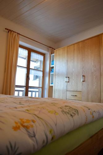 a bedroom with a large bed with a window at Ferienwohnung Seeufer in Bad Bayersoien