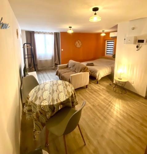 a room with two beds and a table and a couch at Studio confortable au centre de Manosque in Manosque