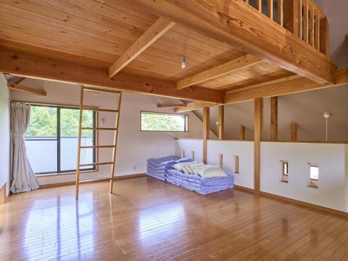 a living room with wooden ceilings and a couch at Nagomiya Hirugano in Gujo