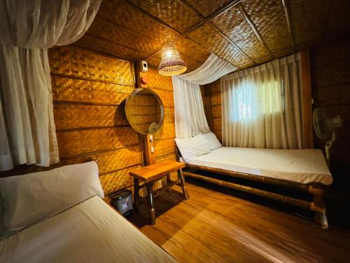 a small room with two beds and a mirror at Tuburan Resort in Panong