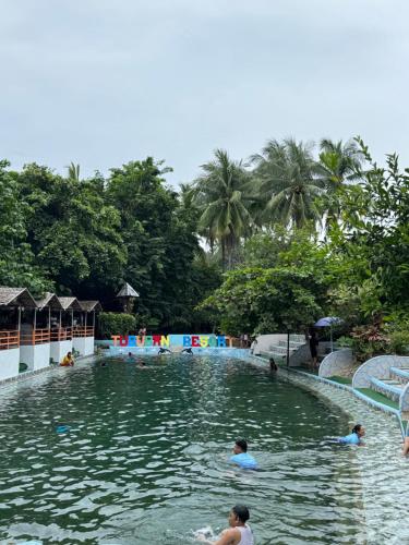 a group of people swimming in a swimming pool at Tuburan Resort in Panong