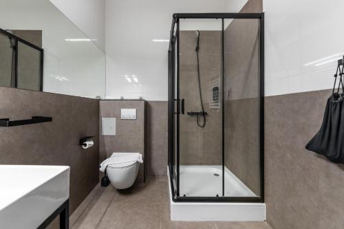 a bathroom with a shower and a toilet and a sink at Apartamenty na Spokojnej in Kołobrzeg