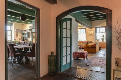 an open door into a living room with a table at Bohemian Experience Wellness, Jacuzzi, Sauna, BBQ, Garden, Sleeps 14 in Kockengen