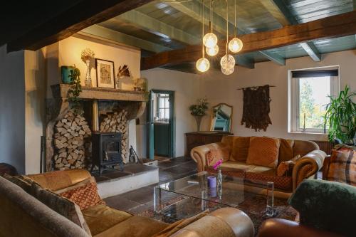 a living room with a couch and a fireplace at Bohemian Experience Wellness, Jacuzzi, Sauna, BBQ, Garden, Sleeps 14 in Kockengen