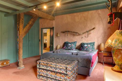 a bedroom with a bed and a trunk in it at Bohemian Experience Wellness, Jacuzzi, Sauna, BBQ, Garden, Sleeps 14 in Kockengen