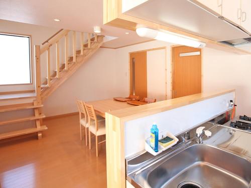 a kitchen with a sink and a table with chairs at Nagomiya Hirugano in Gujo