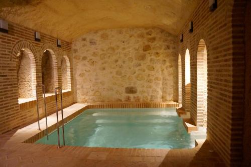 a large indoor pool in a building with a brick wall at Casas de Valois in Hita