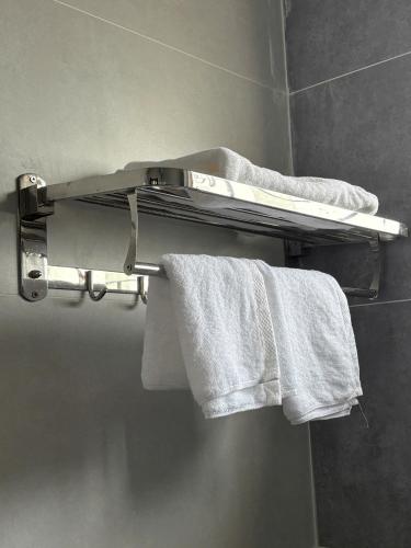 a towel rack in a bathroom with white towels at Long Bình Hotel in Dong Hoi