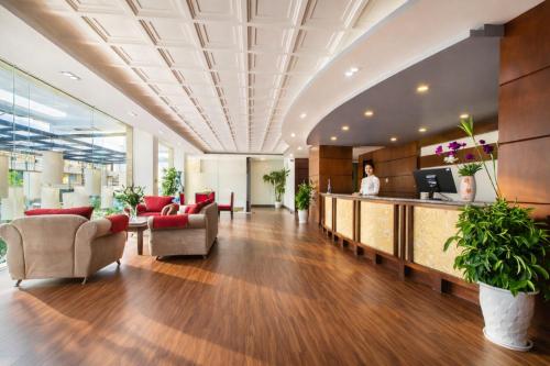 an office lobby with a reception desk and a woman in the background at The Sunriver Boutique Hotel Hue in Hue