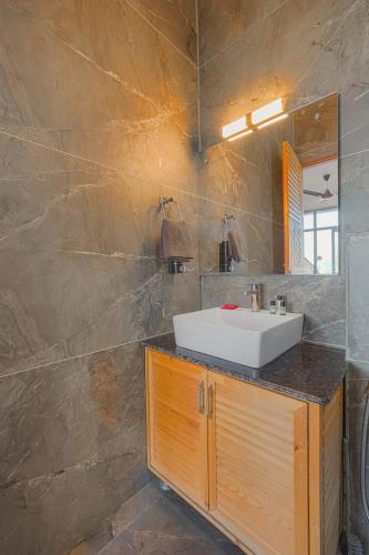 a bathroom with a sink and a mirror at Nirvana By Nest Kasauli 2 BHK Luxury Apartment Rooftop Cafe Free Parking in Kasauli