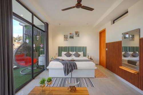 a bedroom with a large bed and a balcony at Nirvana By Nest Kasauli 2 BHK Luxury Apartment Rooftop Cafe Free Parking in Kasauli