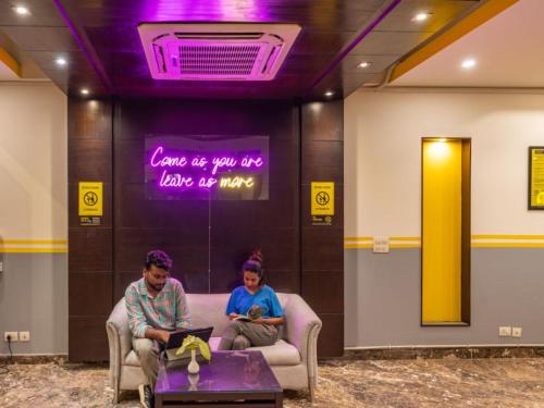 two people sitting in a waiting room with their laptops at The Hosteller Delhi in New Delhi
