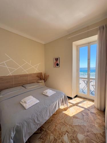 a bedroom with a bed with a view of the ocean at Hotel Gandolfo in Alassio