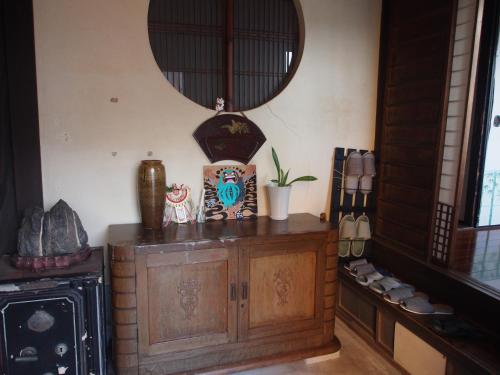 a room with a wooden cabinet and a mirror at The Asagiri Guest House in Tanabe