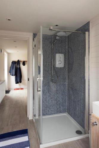 a shower with a glass door in a bathroom at Rose Cottage in Wadebridge