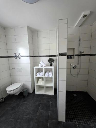 a white bathroom with a toilet and a shower at Apartment Ilmtalblick in Pfaffenhofen an der Ilm