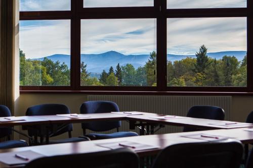 a room with tables and chairs with mountains in the background at Mercure Jelenia Góra in Jelenia Góra