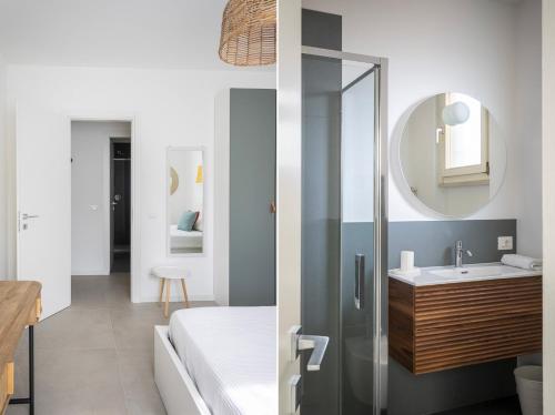 a bathroom with a shower with a sink and a mirror at MoKi by Garda FeWo in Moniga