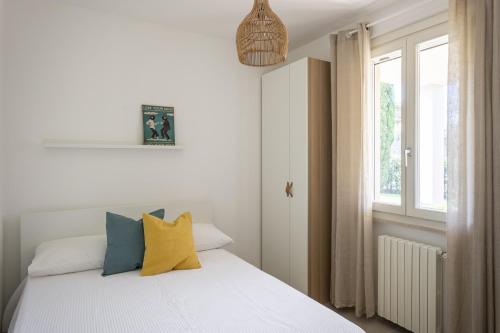 a bedroom with a bed with yellow and blue pillows at MoKi by Garda FeWo in Moniga