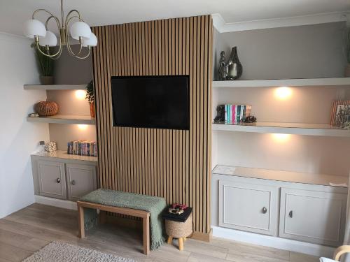 a living room with a television on a wall at Carrick's Cosy Haven in Carrickfergus