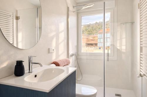 a bathroom with a sink and a toilet and a mirror at Señorial Panorámico by apartamentoscatedralcamino in Burgos