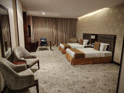 a hotel room with two beds and a chair at Rabigh Park Hotel in Rabigh