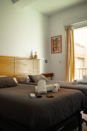 a bedroom with two beds with towels and a window at Hotel de la plage in Banyuls-sur-Mer