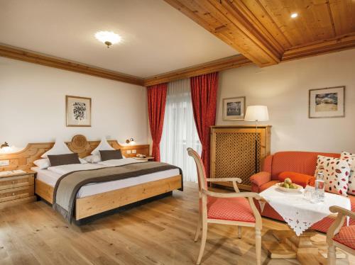 a bedroom with a bed and a table and chairs at Der Verdinser Hof in Schenna