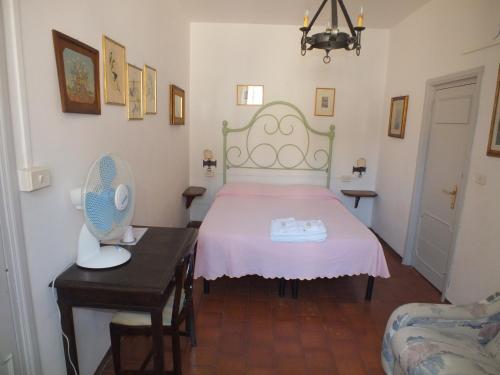 a bedroom with a bed and a table with a fan at Locanda Laudomia in Manciano