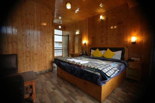 a bedroom with a bed in a wooden room at The Himalayan Drift Cottages in Vashisht