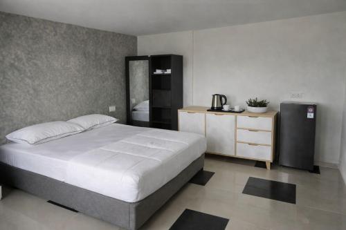 a bedroom with a large bed and a refrigerator at Sea Sky Dreams in Kuta Lombok