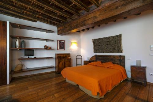 ein Schlafzimmer mit einem Bett mit einer orangefarbenen Decke in der Unterkunft B&B Bonsignori in Florenz