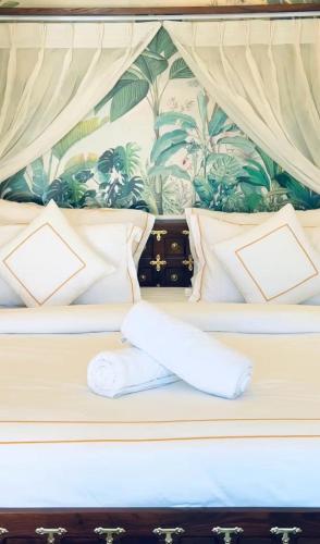 a bed with white sheets and pillows on it at The S - Luxurious Stays in Mahabaleshwar