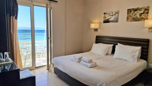 a bedroom with a bed with towels on it at Plaza in Egina
