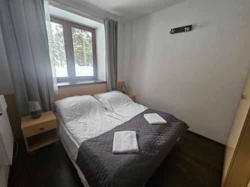 a bedroom with a bed with two towels on it at Przystanek Dolina Kościeliska in Kościelisko