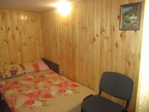 ein Schlafzimmer mit einem Bett und zwei Stühlen darin in der Unterkunft Pershyy Hostel u Cherkasah in Tscherkassy
