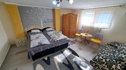 a bedroom with a bed and a table and chairs at Margaréta Panzió in Sárospatak
